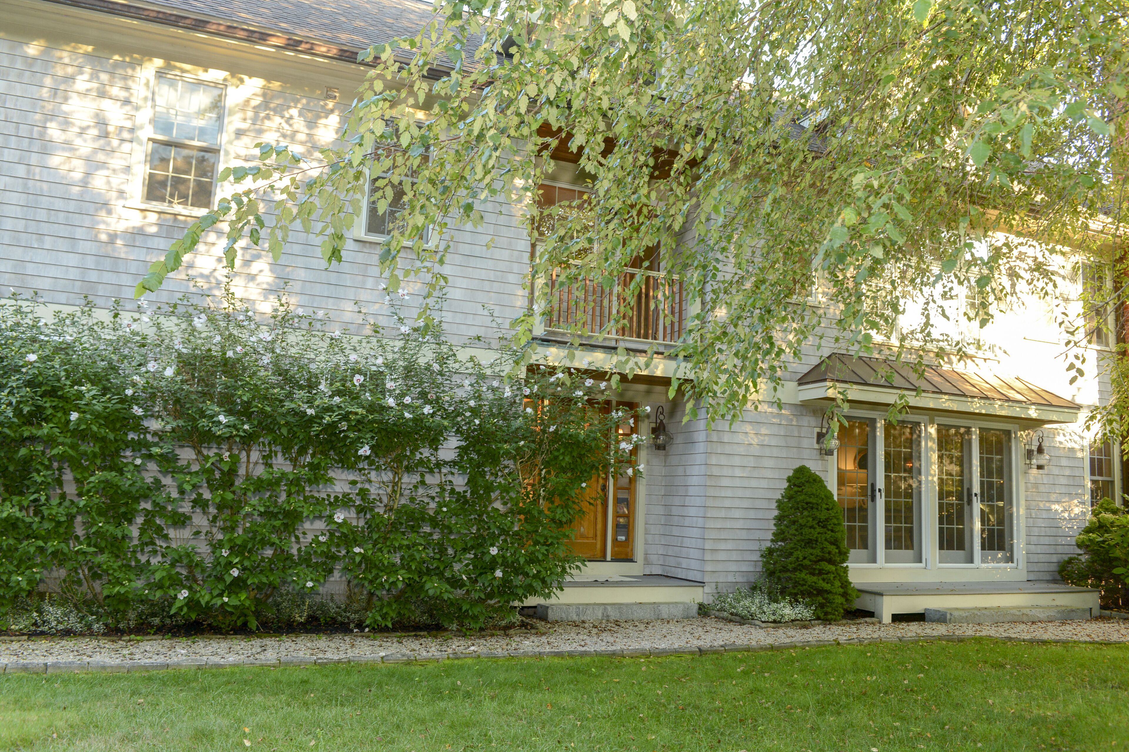 A two-story house with a covered front porch and a small front yard.