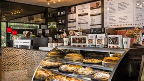 Eine Bäckertheke mit verschiedenen Backwaren, eine Speisekarte darüber und ein Starbucks-Schild im Hintergrund.