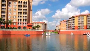 Ein Hotel am Wasserufer mit mehreren Gebäuden, einem ruhigen Fluss und Booten.