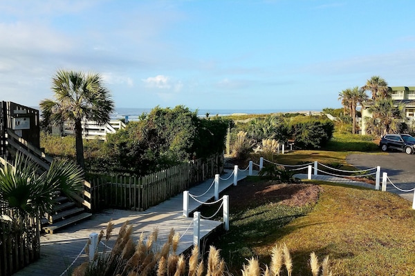 View from deck overlooking lush landscaping and ocean. Short steps to soft sand!