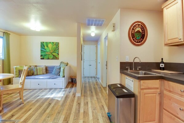 Un espacio habitable compacto con kitchenette, comedor y dormitorio.