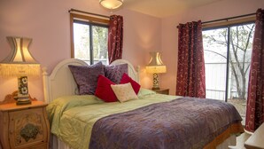A bedroom with a large bed, two bedside tables with lamps, and a window with curtains. - Casita Dulce: 1 Bedroom., 1 Bath, AC, Private Garden – Easy Walk to all Santa Fe (Santa Fe)