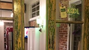 Una cocina con armarios blancos, una pared de ladrillo y un cartel que dice 'It's KOL Inside'.
