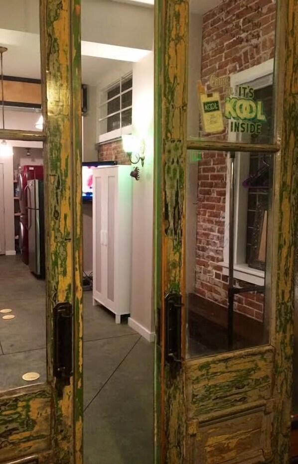 A kitchen with white cabinets, a brick wall, and a sign that reads "It's KOL Inside."