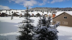 A snow-covered residential area with houses and a mountain in the background. - The Cozy Chalet in Gallatin Range -Warm and Inviting Mountain Chalet (Big Sky)