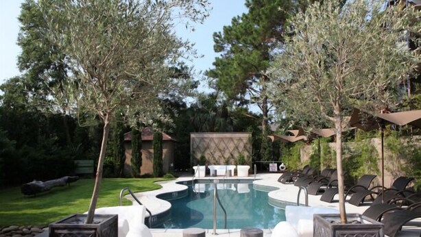 A swimming pool with lounge chairs and a deck area.