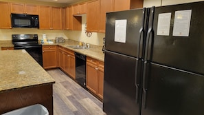 Kitchen features a sink, stainless steel range hood, and modern appliances.