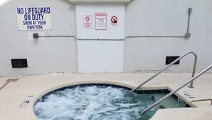 A hot tub with a sign indicating no lifeguard on duty and a warning about maximum occupancy. - MBV 6Br/5Ba - 302B (Myrtle Beach)