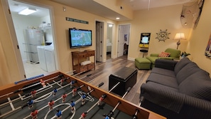 Relax and unwind in this inviting space, featuring a foosball table, TV, and cozy seating area.