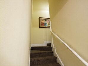 A staircase with a patterned carpet, a white handrail, and a wall-mounted picture. - MBV 6Br/5Ba - 302B (Myrtle Beach)