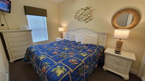 A bedroom with a bed, nightstands, a dresser, a television, and a wall-mounted mirror. - MBV 6Br/5Ba - 302B (Myrtle Beach)