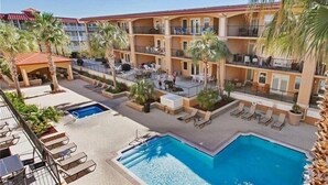 A hotel with multiple balconies, a swimming pool, and outdoor seating areas. - Luxury 3BR 2.5 B Condo Just Steps from the Ocean! (Tybee Island)