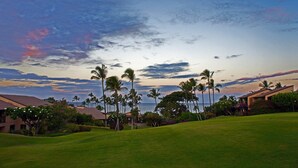 Ein Golfplatz mit Blick auf den Ozean und einem Sonnenuntergangshimmel.