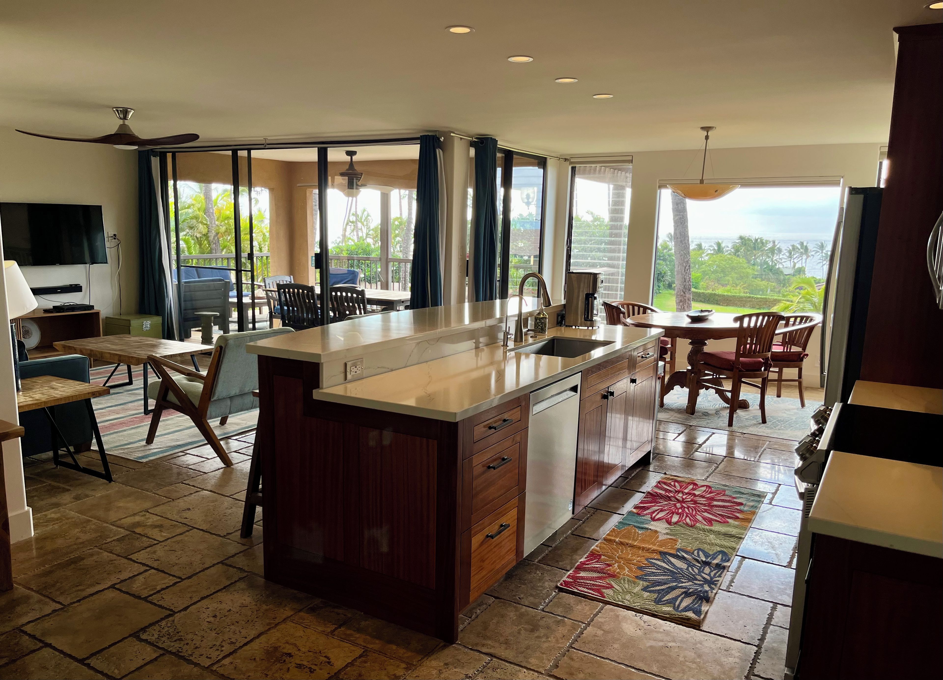 A spacious kitchen with a large island, modern appliances, and a view of the outdoors.