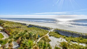 A beach with a wooden boardwalk, sandy dunes, and a clear view of the ocean. - Gorgeous direct oceanfront- end unit in highly desirable location! 
 (North Myrtle Beach)