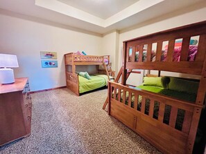 A room with bunk beds, a desk with a lamp, and a carpeted floor. - Family-friendly Lakefront Home w/Kayaks, Paddleboards & More-Close to Silverwood (Hayden)