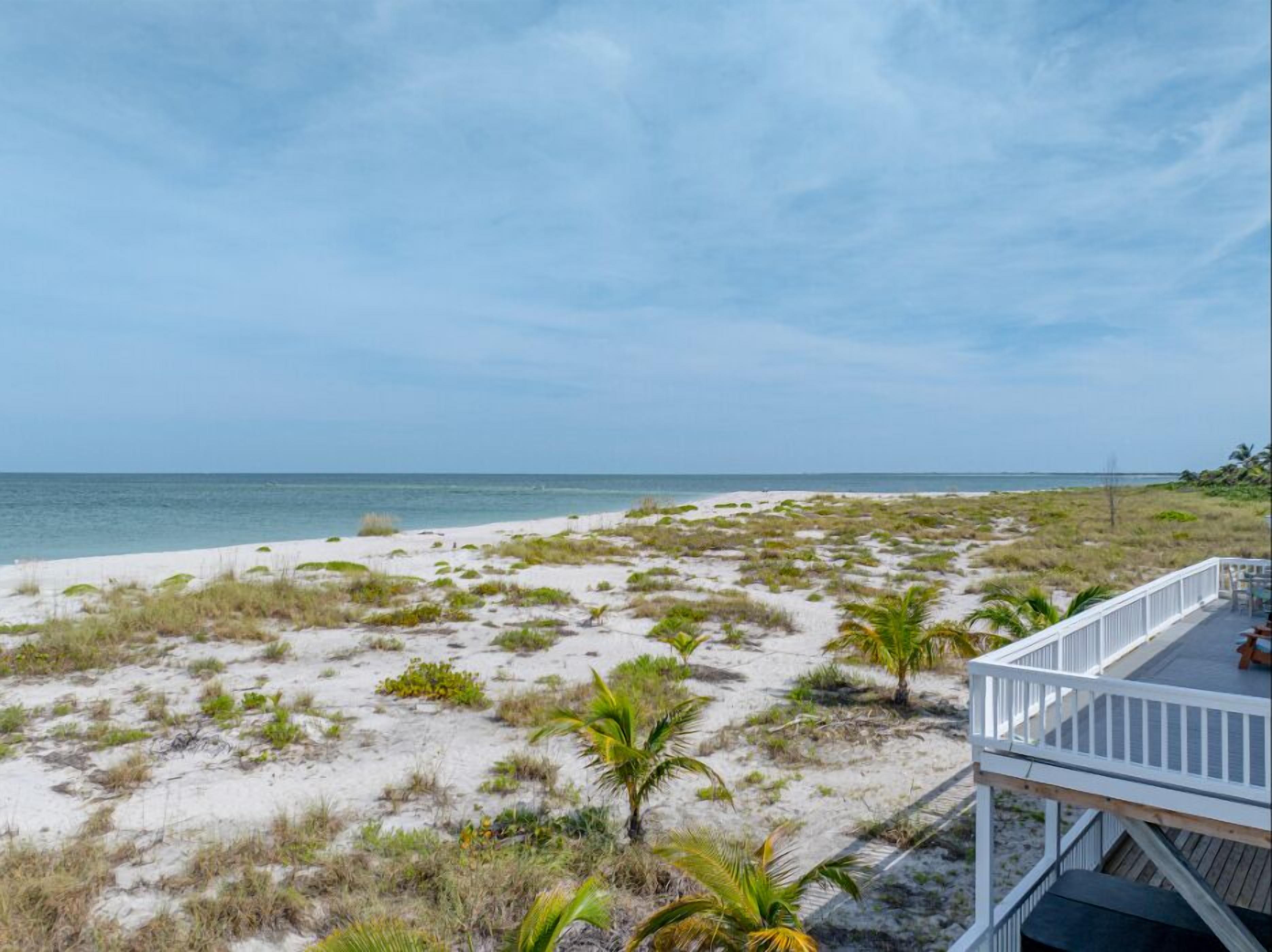 Ein Strand mit einer weißen Terrasse mit Blick aufs Meer.