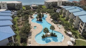 A resort with a central swimming pool, multiple buildings, and a view of the ocean. - NEWLY TOTALLY RENOVATED   5⭐️STAR sleeps 8  (Panama City Beach)