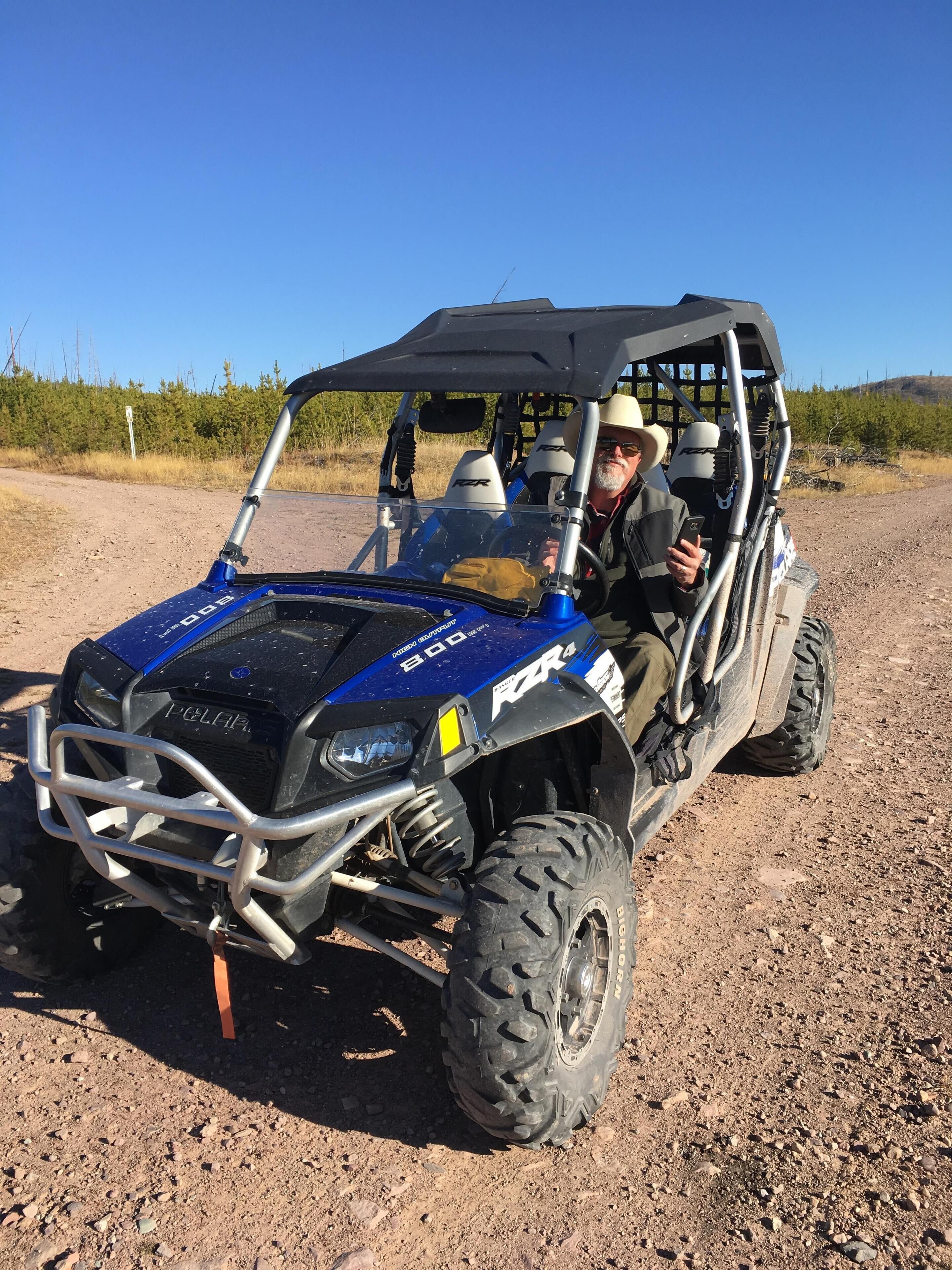 Ein Polaris RZR4 Geländewagen auf einer Schotterstraße.