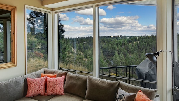 Una habitación con un ventanal que ofrece vistas a un área boscosa.
