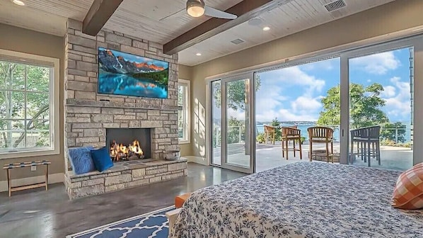 A spacious room with a fireplace, large windows, and a view of the outdoors.
