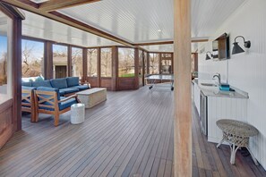 A spacious deck with a sofa, a table, and a small round table. - Sleeps 12, amazing view, tennis court, basketball court, beaches (Edgartown)