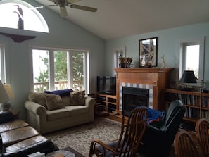 A living room with a fireplace, a sofa, a television, and a bookshelf.