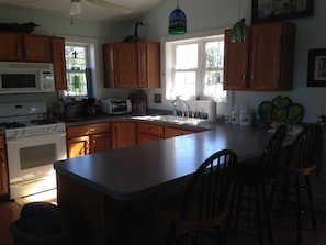 A kitchen with wooden cabinets, a microwave, a toaster, and a sink.
