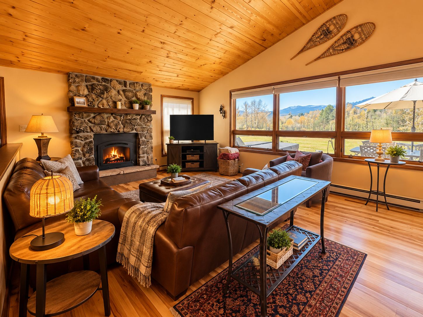 Relax by the stone fireplace in this cozy living room w/ natural light,mtn views