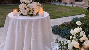 A round table with a white tablecloth, surrounded by white flowers and candles, set against a sunset backdrop. - Romantic Guest House, Spectacular Views, Close to everything , Private Hot Tub (San Diego)