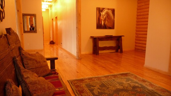 A cozy living room with a wooden floor, a sofa, a bench, and a rug. - Premium Mountain Retreat On Over 2 Acres With Sweeping Views-hot Tub/Pool Table (Ruidoso)