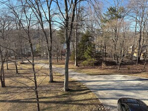 A paved path through a wooded area with trees and a parked car. - 5 BR 4.5 BA with a Stunning Lake View and Boat Slip (LaFollette)