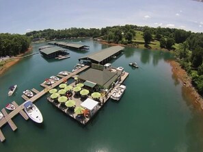 Un port de plaisance doté de quais, de bateaux et d’un bâtiment surmonté d’un toit végétalisé.