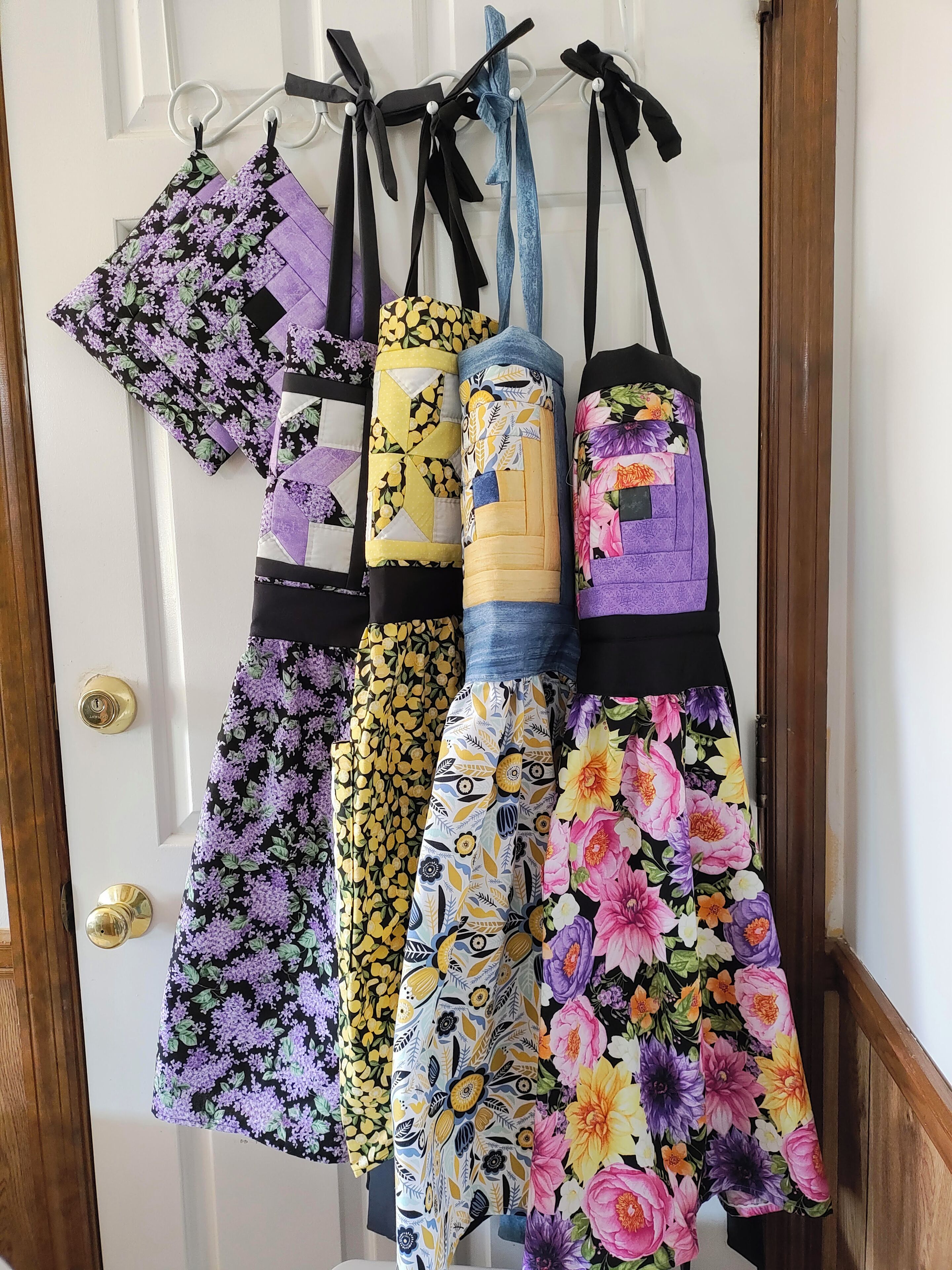 A door with a set of aprons hanging on a rack.