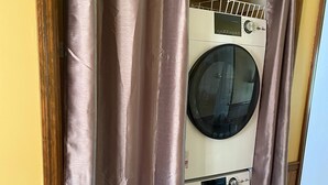 A laundry room with two stacked washing machines and a drying rack. - Scenic View Lodging ~ A Country Suite with Country Charm. (Gap)