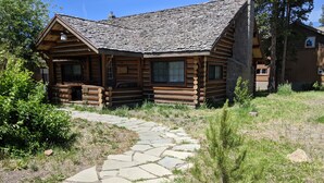 Eine Blockhütte mit einem Steinweg, der zum Eingang führt.