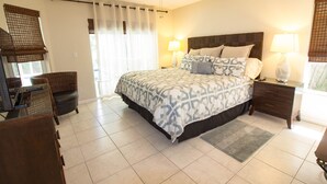 Una habitación de hotel ordenada con una cama grande, un escritorio y una silla.