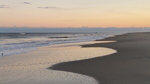 Une plage avec un large rivage sablonneux et des vagues douces.