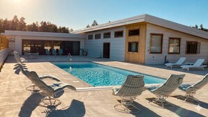 A modern house with a swimming pool, lounge chairs, and a covered patio area. - Private Pool Paradise - MCM Luxury Black Hills (Nemo)