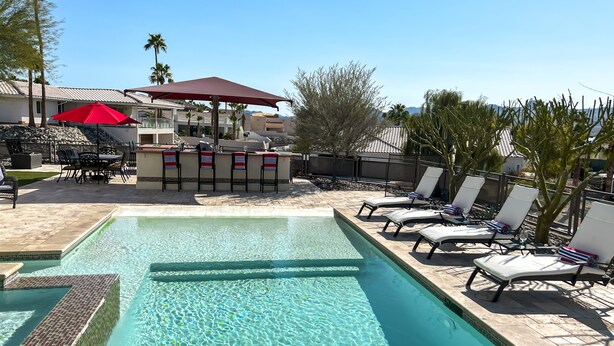 A swimming pool with lounge chairs and a bar area. - Luxury Estate in Prime Location w Panoramic views of Lake Havasu (Lake Havasu City)