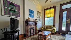 Una sala de estar con chimenea, televisor, sofá y mesa de centro.