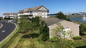 A multi-story residential building with a parking lot and a lake view.