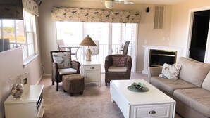 A living room with wicker furniture, a white coffee table, and a beige sofa.