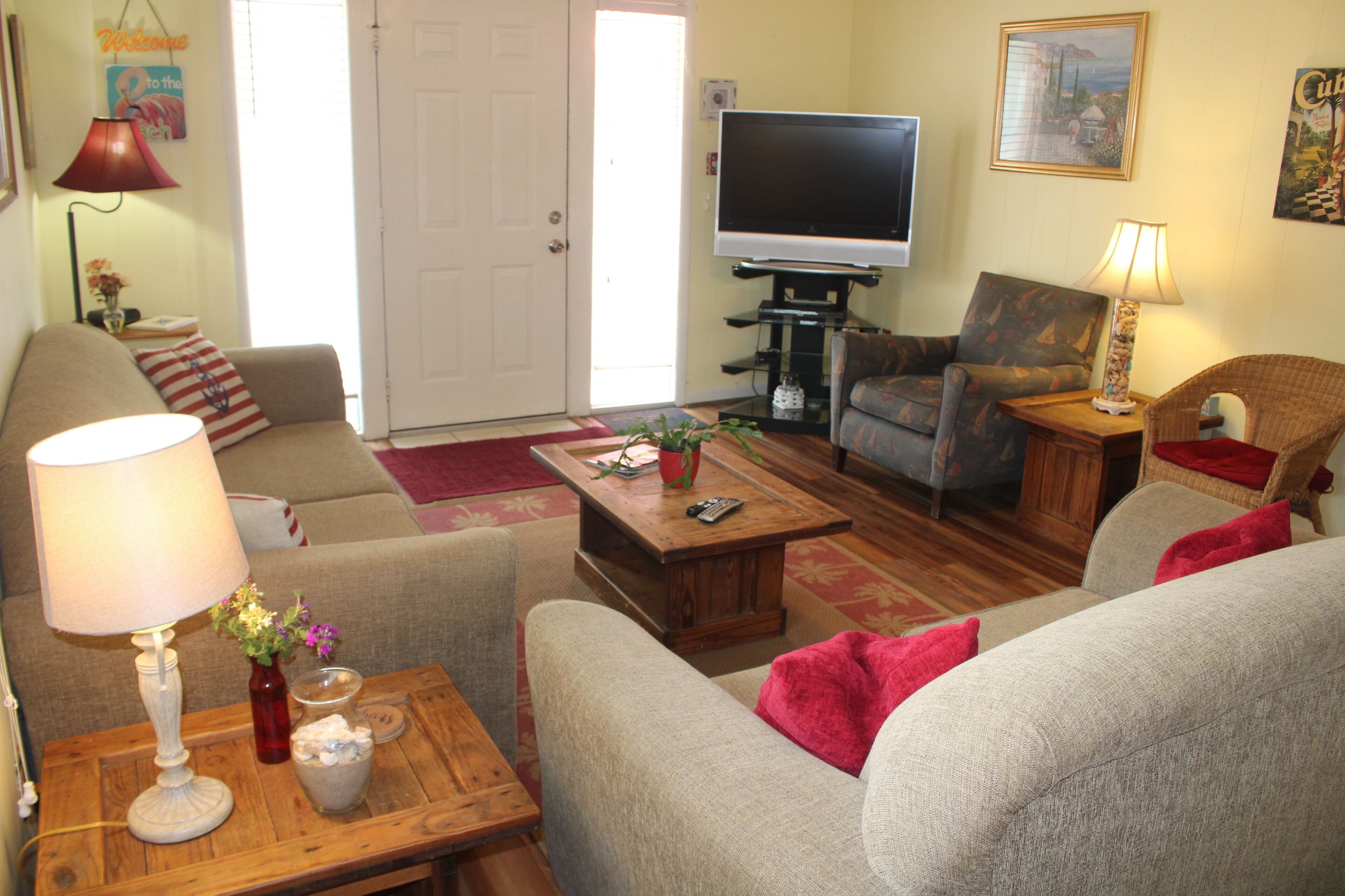 A living room with a sofa, armchair, coffee table, and a TV.