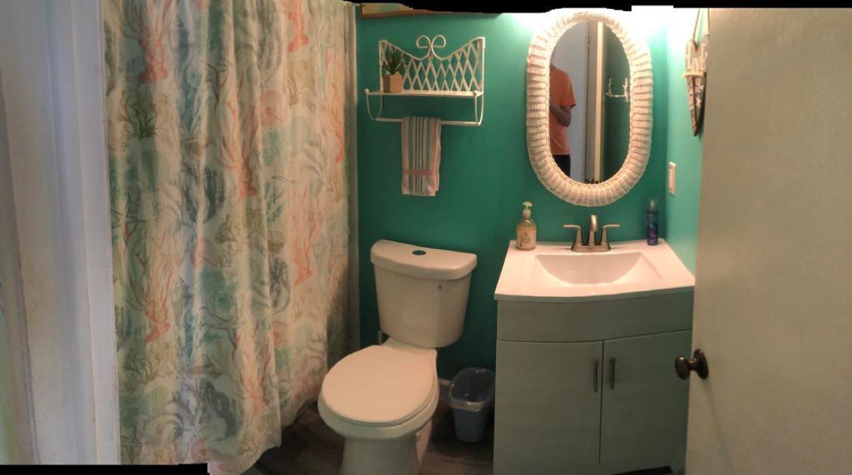 Un baño con inodoro, lavabo y espejo.