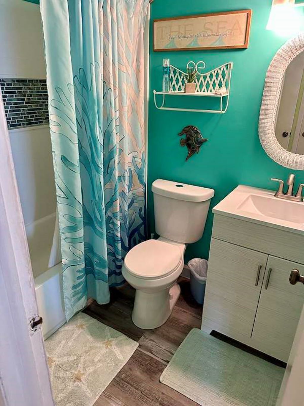 Une salle de bain équipée de toilettes, d’un lavabo et d’un rideau de douche.