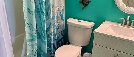 Une salle de bain équipée de toilettes, d’un lavabo et d’un rideau de douche.