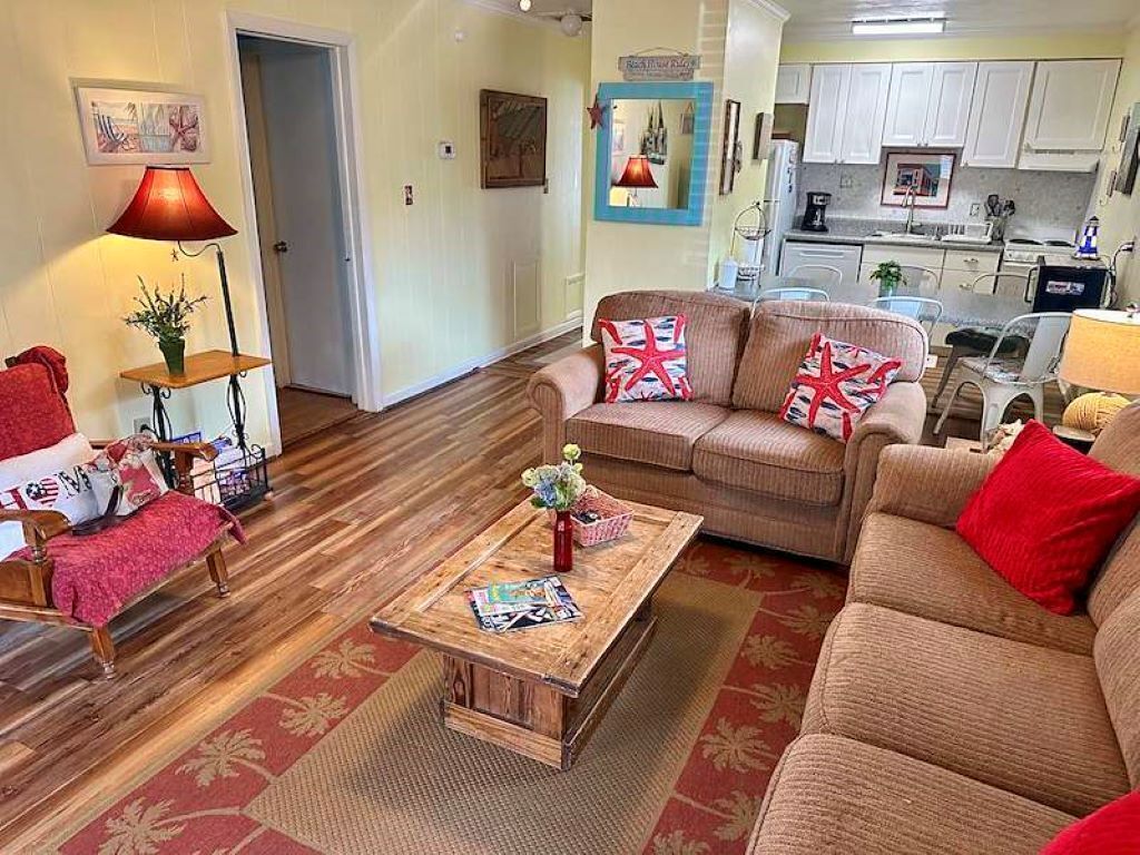 A living room with a sofa set, a coffee table, and a lamp.