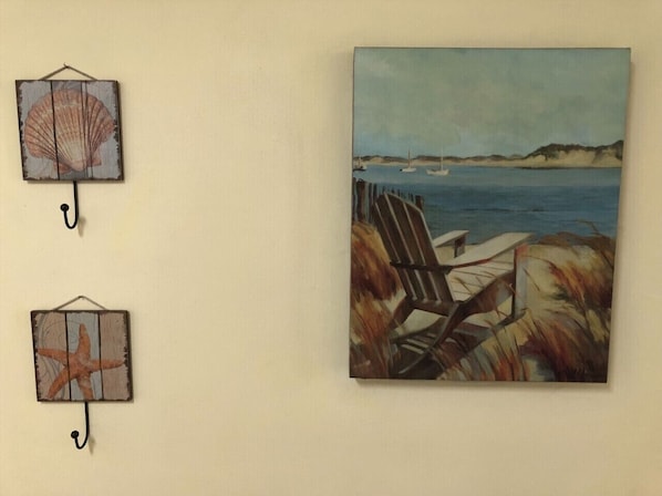 A beach scene with a chair and a painting of a beach.