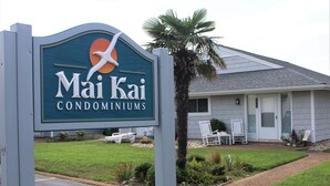 A sign for Mai Kai Condominiums with a palm tree and outdoor seating area. - Highly rated, clean, ground floor condo w/pool; steps to beach. (Virginia Beach)